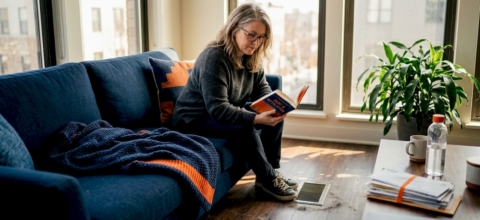 Woman relaxing near sunlit floor vent
