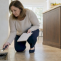 Woman inspecting dusty air duct at home