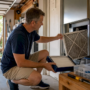 Homeowner replacing HVAC air filter at furnace unit