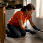 Person removing baseboard vent cover to clean