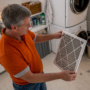 Man inspecting air filter in basement