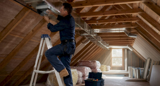 Technician installing home ventilation ducts