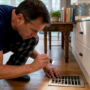 Man inspecting dust inside home air vent