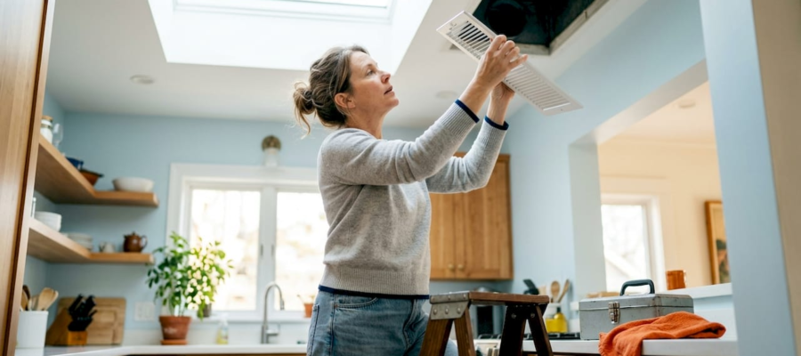 Woman inspecting home air vent register