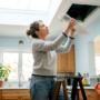 Woman inspecting home air vent register