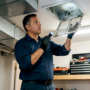 HVAC technician inspecting moldy air vent