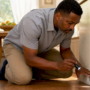 Man inspecting HVAC return vent in living room