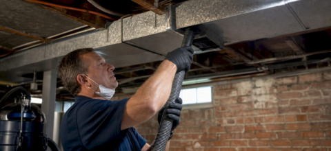 Technician inspecting residential ductwork in attic
