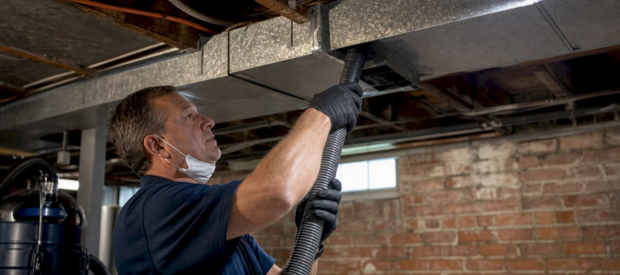 Technician inspecting residential ductwork in attic