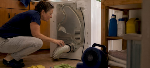 Homeowner inspecting dryer vent connection