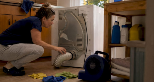 Homeowner inspecting dryer vent connection