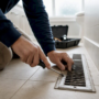 Hands removing vent register cover with screwdriver
