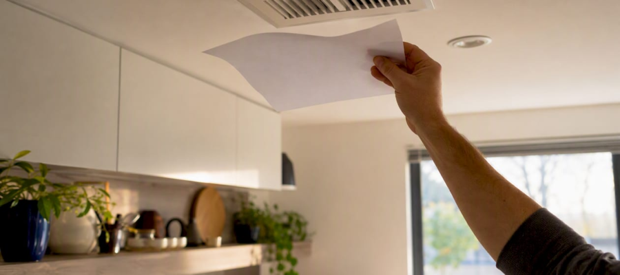 Hand holding paper fluttering at air vent