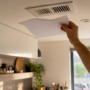 Hand holding paper fluttering at air vent