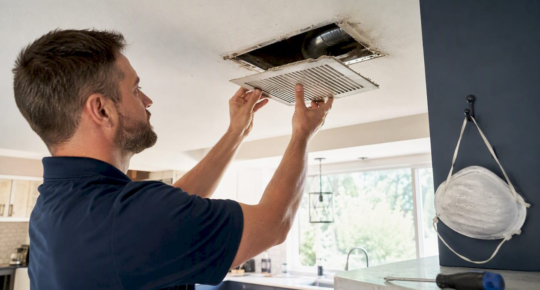 Hands removing home ceiling air vent register