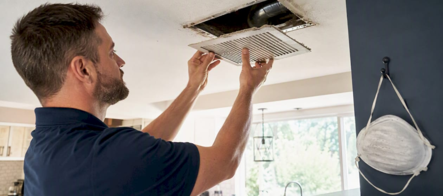 Hands removing home ceiling air vent register