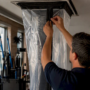Technician sealing HVAC duct containment in office ceiling
