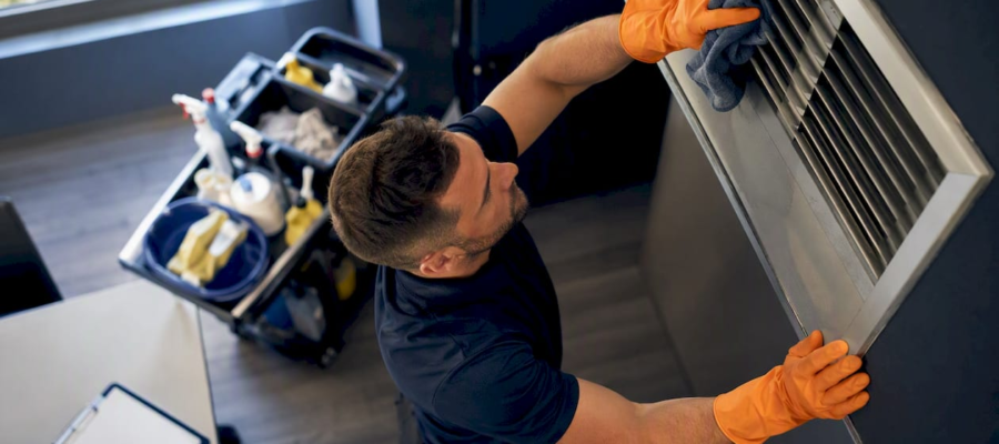Hands wiping HVAC duct register cover