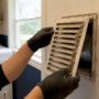Hands removing dusty air vent cover