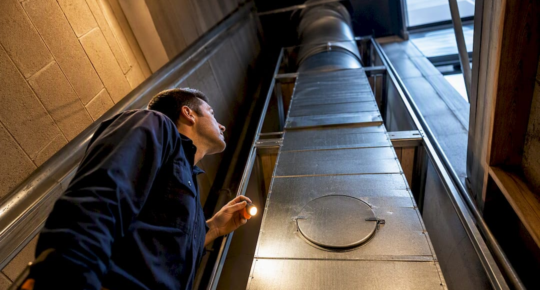 Technician inspecting multifamily dryer exhaust shaft