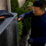 Technician rinsing an outdoor condenser coil