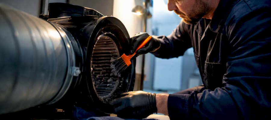 Technician cleaning an inline dryer booster fan