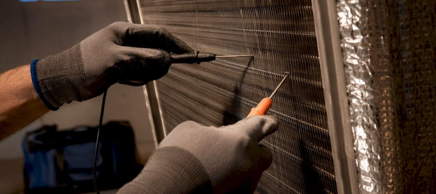 Technician measuring temperature across HVAC coil