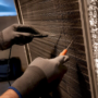 Technician measuring temperature across HVAC coil