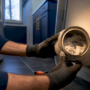 Technician inspecting lint inside dryer vent
