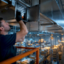 Technician inspecting warehouse ductwork