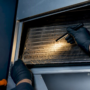 Technician inspecting a dirty evaporator coil