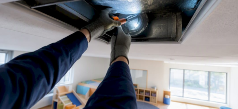 Technician inspecting daycare classroom air duct