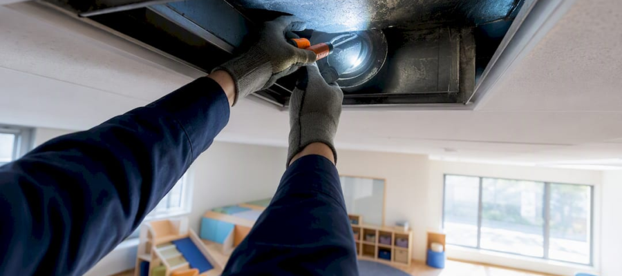Technician inspecting daycare classroom air duct