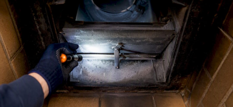 Hand inspecting fireplace damper plate