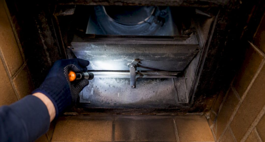 Hand inspecting fireplace damper plate
