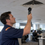 Facility manager checking office diffuser airflow