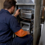 Technician inspecting shielded HVAC UV-C lamp
