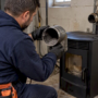 Technician inspecting ash inside pellet stove vent