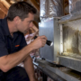 Technician inspecting damp plenum insulation