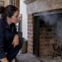 Technician observing smoke spilling from fireplace