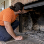 Technician inspecting a partially blocked fireplace flue