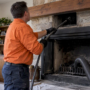 Chimney sweep brushing creosote from a flue