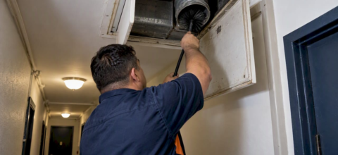 Technician cleaning an apartment dryer exhaust duct