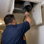Technician cleaning an apartment dryer exhaust duct