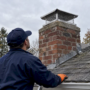 Professional checking a capped suburban chimney