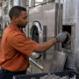 Technician cleaning a hospital dryer exhaust duct