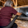 Technician cleaning an opened HVAC duct